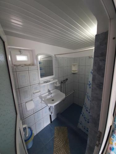 a small bathroom with a sink and a mirror at Vila Andra in Costinesti