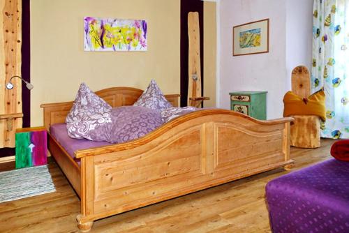 ein Schlafzimmer mit einem Holzbett mit einer lila Matratze in der Unterkunft Haus Luise in Krün
