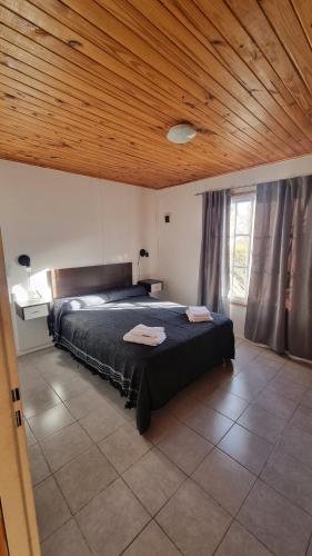 een slaapkamer met een groot bed en een houten plafond bij Departamento Tilcara in Neuquén