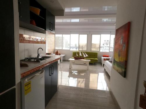 uma cozinha com um lavatório e uma sala de estar em La Posada De Lulú em San Andrés