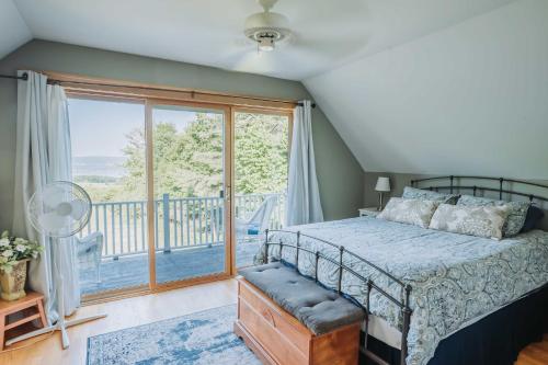 ein Schlafzimmer mit einem Bett und einem großen Fenster in der Unterkunft Charming Hammondsport Home with Lake Views and Pool! in Hammondsport