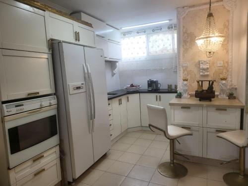 a kitchen with a refrigerator and a table and chairs at תהילה בכנרת in Tiberias