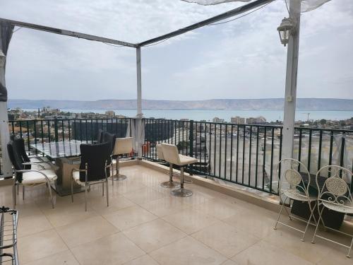 a balcony with chairs and a view of the water at תהילה בכנרת in Tiberias