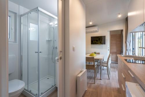 a bathroom with a glass shower and a table at Giardino Sukošan - new mobile houses in olive garden, EV plug-in station in Sukošan