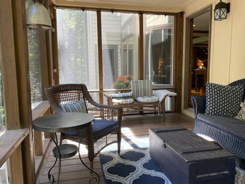a screened in porch with chairs and a table at Beautiful Custom-built, Lodge-like Kerr Lake Home, non-smoking in Henderson