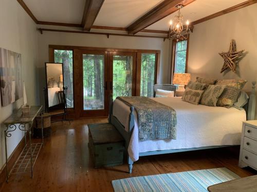 a bedroom with a large bed and a chandelier at Beautiful Custom-built, Lodge-like Kerr Lake Home, non-smoking in Henderson