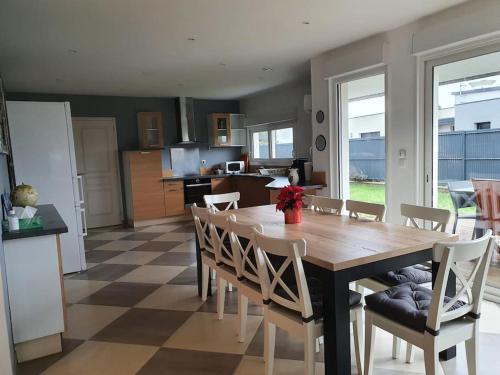 une cuisine et une salle à manger avec une table et des chaises en bois dans l'établissement Maison spacieuse et lumineuse à 2mns des plages, à Locquirec