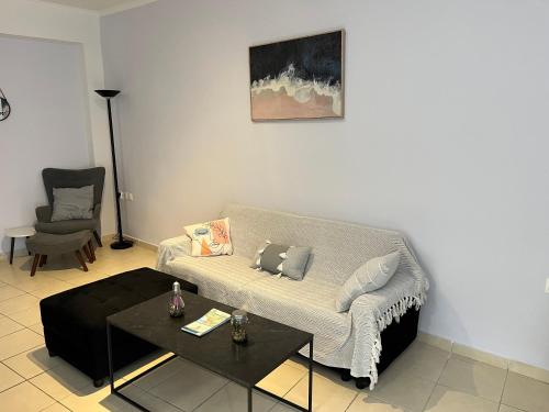 a living room with a couch and a table at Karma - 2 bedroom apartment in Zakynthos Town
