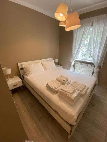 sypialnia z łóżkiem z białą pościelą i oknem w obiekcie Casa Ceroni w Rzymie