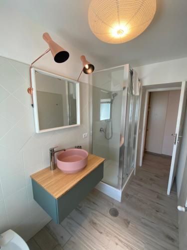W łazience znajduje się różowa umywalka i lustro. w obiekcie Casa Ceroni w Rzymie