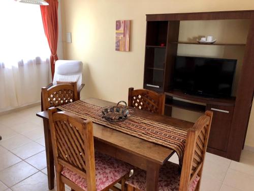 a dining room table with chairs and a television at Casa La Quinta in Villa Carlos Paz