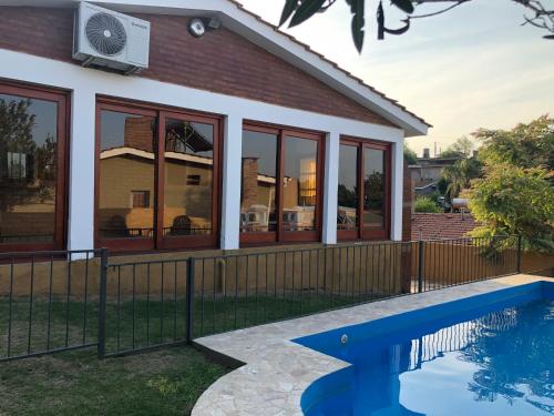 a house with a swimming pool in front of it at Casa La Quinta in Villa Carlos Paz
