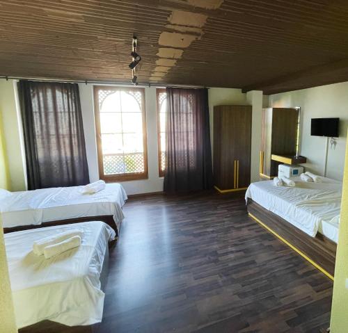 a hotel room with two beds and a television at Hotel Hiserra in Prizren