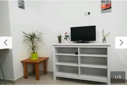 białe centrum rozrywki z telewizorem i stołem w obiekcie Corralejo city beach w Corralejo