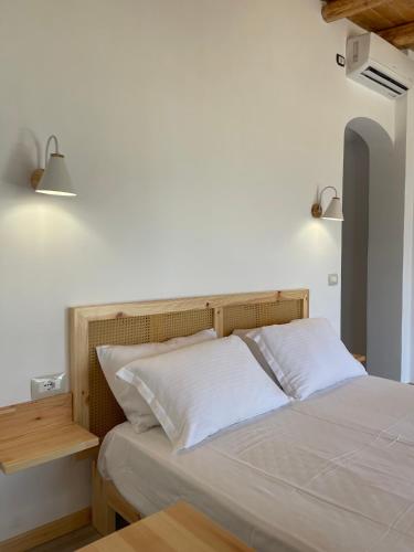 a bedroom with a bed with white sheets and two lamps at Vila Milo in Himare