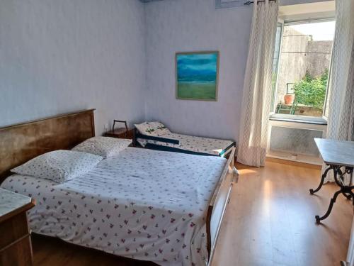 une chambre avec deux lits et une fenêtre dans l'établissement Maison de village 8 couchages, à La Livinière