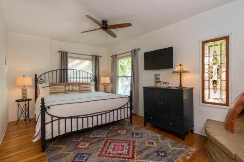 a bedroom with a bed and a ceiling fan at Adobe Rose Inn in Tucson