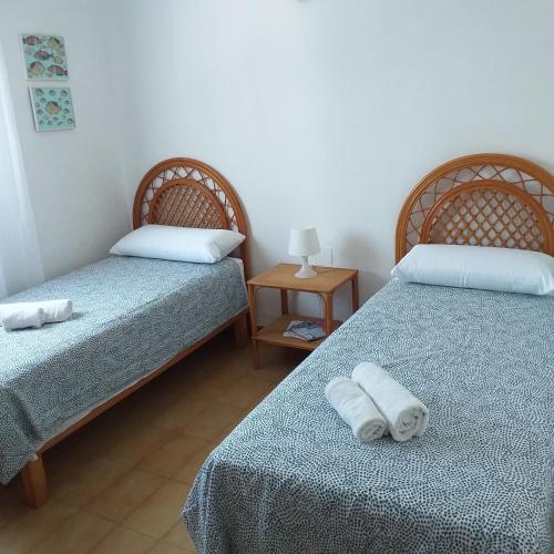 two beds in a room with two towels on them at Formenterasuite 16 in Es Pujols