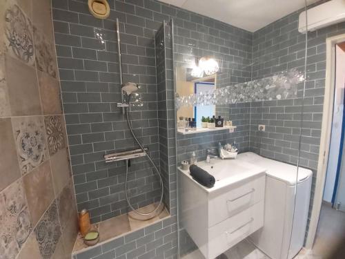 une salle de bain avec un lavabo blanc et une douche dans l'établissement Nouveau! Studio avec vue mer exceptionnelle, à La Grande Motte