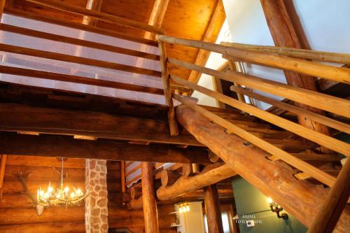 a room with wooden ceilings and a chandelier at Holzhaus Wildsbergblick in Beiseförth