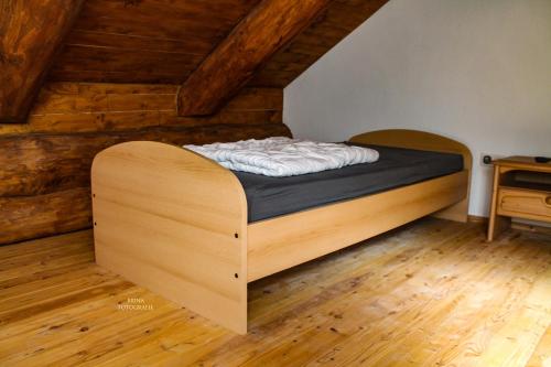 Cama en habitación con paredes y suelo de madera en Holzhaus Wildsbergblick, 