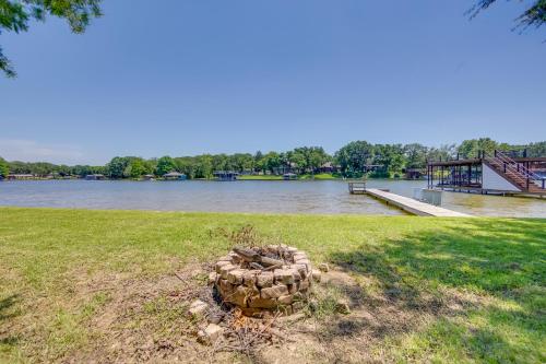 a pile of rocks in the grass next to a river at Dock, Deck and Kayaks Home on Cedar Creek Reservoir in Mabank