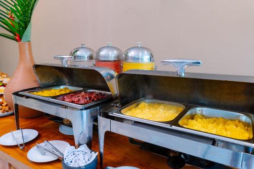 Dos bandejas de comida sobre una mesa en Miola Hotel, en Porto Seguro