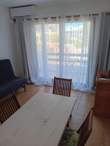 a living room with a table and chairs and a large window at Formenterasuite 16 in Es Pujols