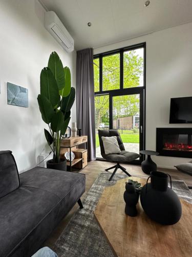 a living room with a couch and a fireplace at Traum Ferienhaus mit Dachterrasse am Veluwemeer in Hulshorst