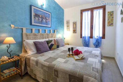 - une chambre avec un grand lit et un mur bleu dans l'établissement ClickSardegna Villa Lavinia con piscina e accesso alla laguna Calich, à Casa Linari