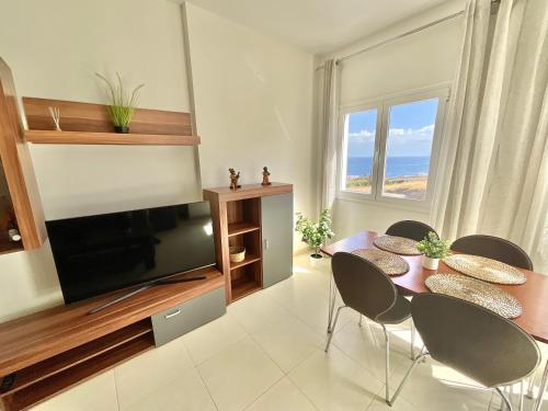 a living room with a table and chairs and a television at ChocolateCream Luxury in Bajamar