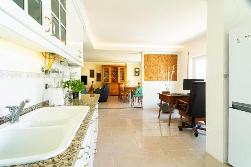 una cucina e un soggiorno con lavandino e scrivania di Family Comfort House a Seixal