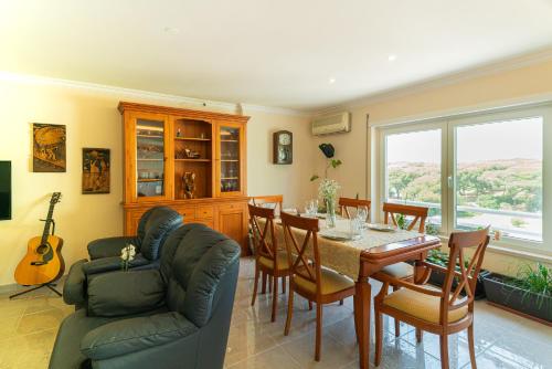una sala da pranzo con tavolo e sedie di Family Comfort House a Seixal