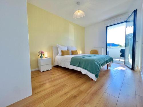 um quarto com uma cama e uma grande janela em Lanester - Le Parc à bois - Wifi Fibre - Balcon - Parking privé em Lanester