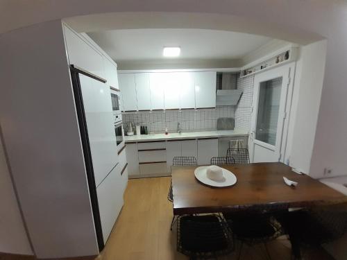 a kitchen with a wooden table and a white refrigerator at Villa suzi in Aydın