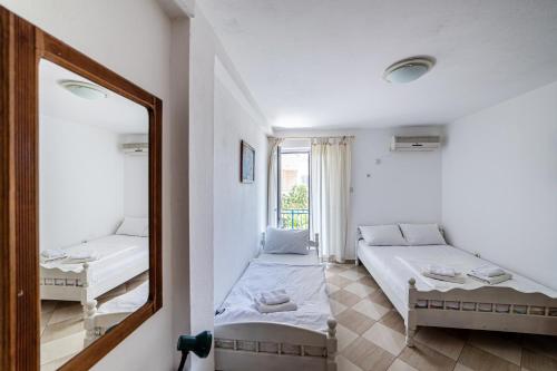 Habitación con 2 camas y espejo. en Apartments Vila Nikolić Rafailovići, en Rafailovici