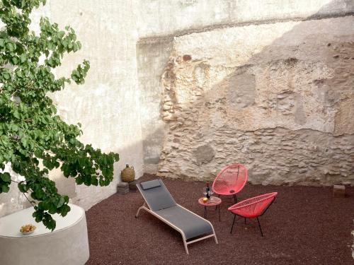a patio with chairs and a table and a wall at La Santa in Almagro
