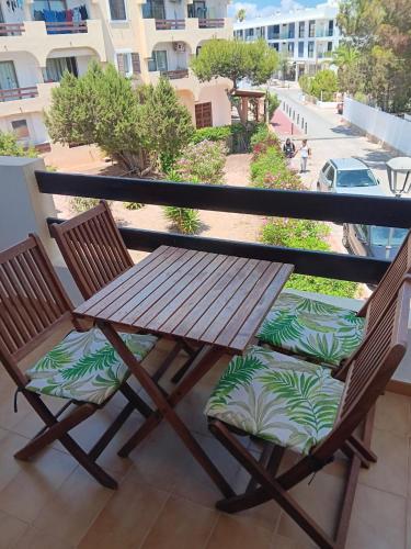 a wooden table and two chairs on a balcony at Formenterasuite 16 in Es Pujols