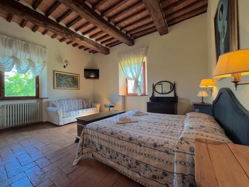 a bedroom with a large bed and a couch at Hotel Relais Santa Genoveffa in Paganico