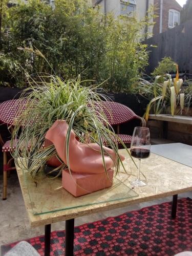 a table with a potted plant and a glass of wine at DERBY in Derby