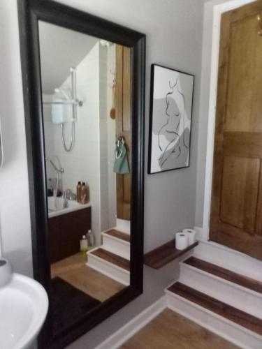 a bathroom with a mirror next to a sink at DERBY in Derby