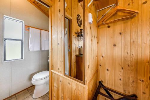 a wooden bathroom with a toilet and a window at Tiny Home with Covered Porch in Cloudcroft Area! in Mayhill