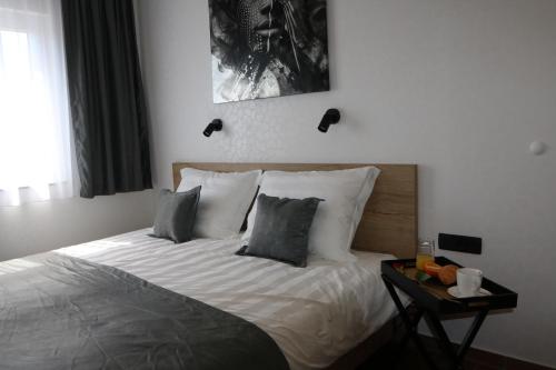um quarto com uma cama com lençóis brancos e almofadas em Avangard HOME I 