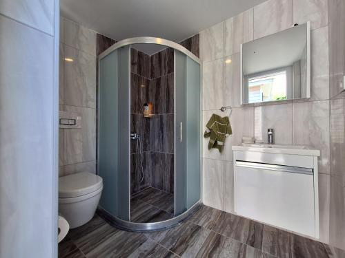 a bathroom with a shower and a toilet and a sink at Villa İnci in Cesme
