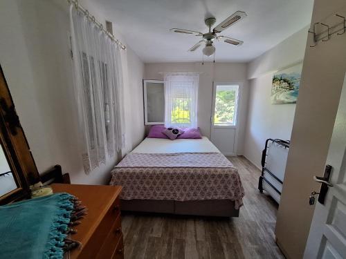 a bedroom with a bed and a ceiling fan at Villa İnci in Cesme
