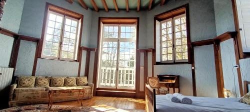 a living room with a couch and windows at Chateau de la Grand'Maison in Bellême