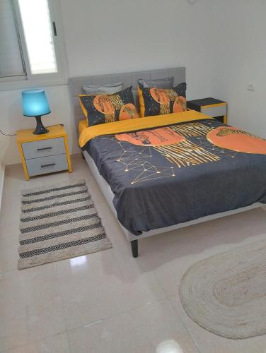 um quarto com uma cama com um candeeiro azul e um tapete em פטל em Bersebá
