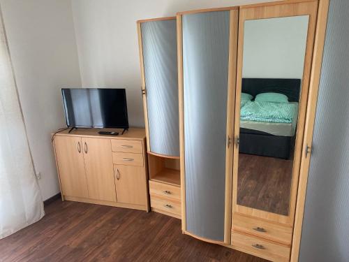 a cabinet with a mirror and a television in a room at Erdgeschoss Wohnung 2 Schlafzimmer in Bayreuth