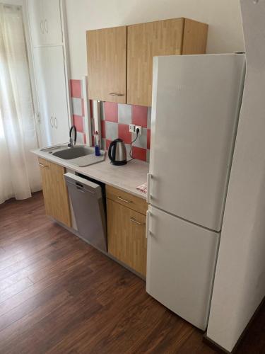 a kitchen with a white refrigerator and wooden cabinets at Erdgeschoss Wohnung 2 Schlafzimmer in Bayreuth