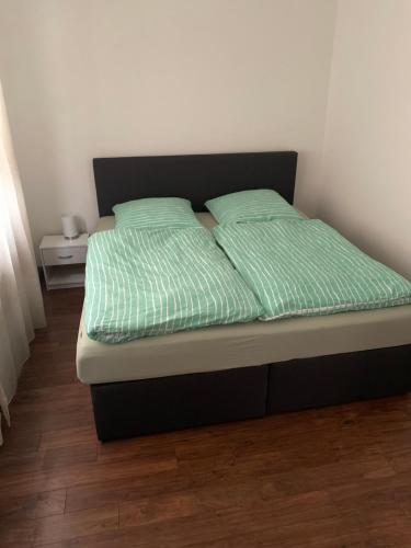 a bed with two green pillows on top of it at Erdgeschoss Wohnung 2 Schlafzimmer in Bayreuth